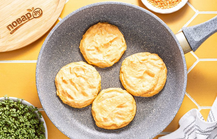 1. Этап. Оладьи из красной чечевицы: Разогрейте сковороду на среднем огне. Выложите порционно тесто, сформируйте оладушки. Лучше делать их не сильно толстыми, примерно 1-1.5 ст.л. теста на одну штуку. Обжарьте до румяного цвета пару минут на среднем огне.