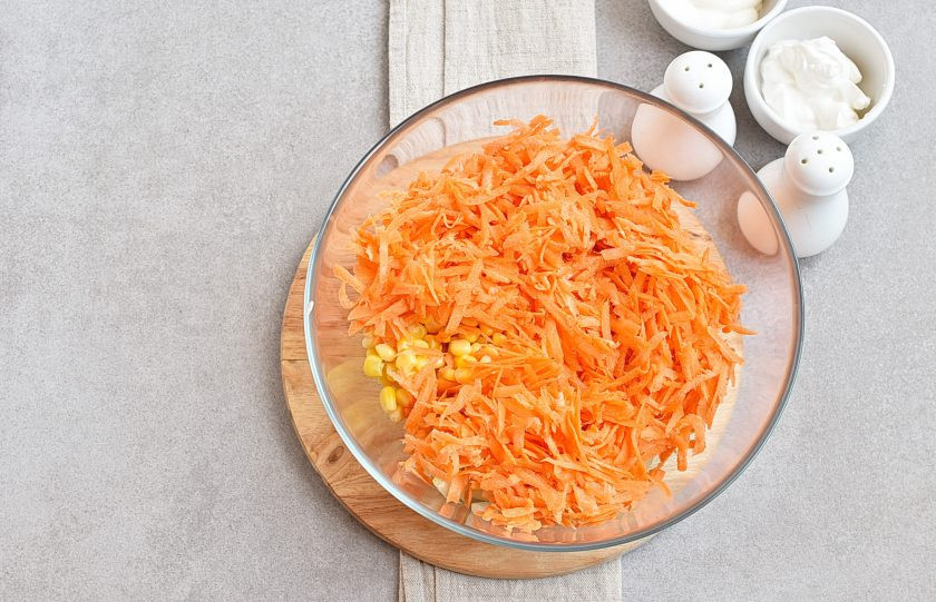 1. Этап. Салат с морковью и кукурузой: Добавьте натертую на крупной терке морковь.