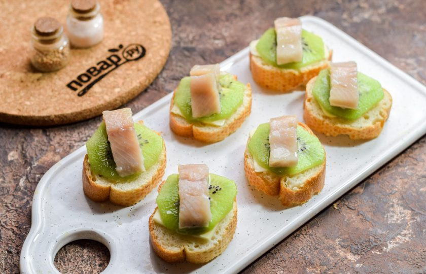 1. Этап. Бутерброды с селедкой и киви: Поверх киви выложите по одному кусочку селедки.