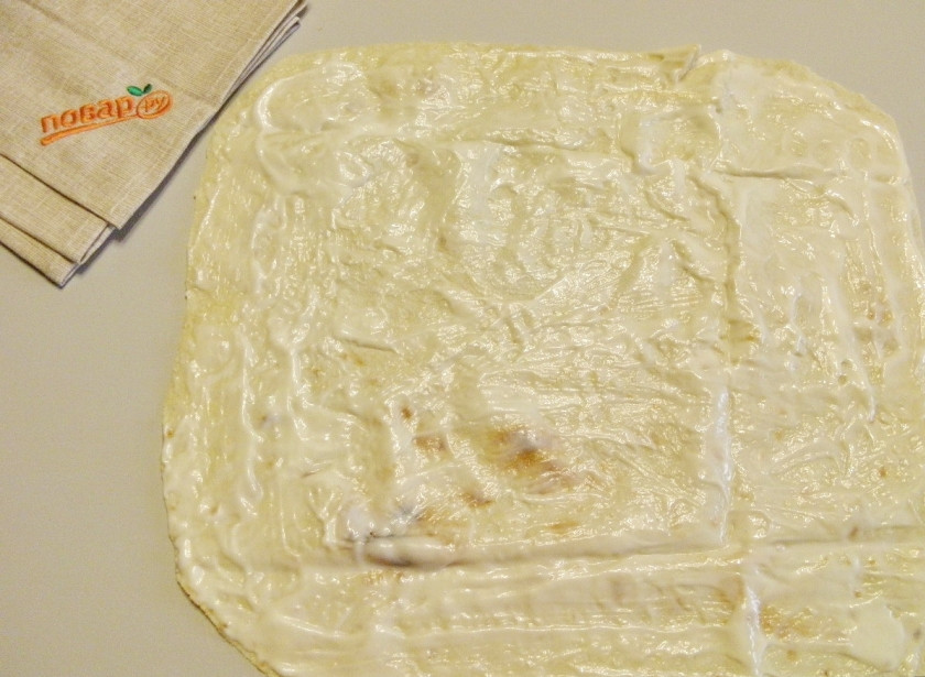 1. Этап. Рулет из лаваша на Новый Год: Расстелите на столе первый лаваш. Смажьте его хорошо майонезом.