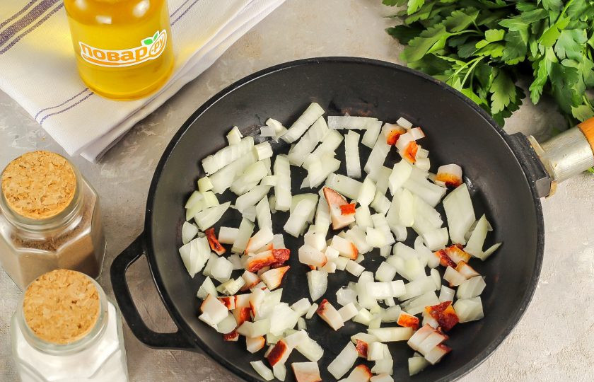 1. Этап. Утка по-чешски: Сало нарежьте мелкими кубиками. Очистите репчатый лук от кожуры, промойте и также нарежьте мелкими кубиками. Влейте в сковороду растительное масло и прогрейте на плите. Всыпьте луковую нарезку и нарезку сала. Поджарьте на среднем нагреве примерно 5-6 минут до румяности, не забывая перемешивать.