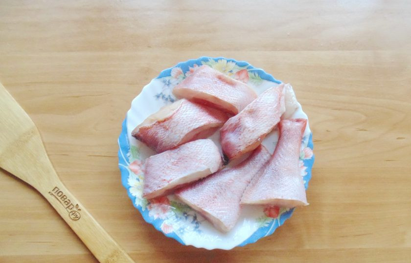 1. Этап. Морской окунь в томатном соусе: Окуня очистите, выпотрошите, помойте внутри и снаружи. Нарежьте порционными кусочками.