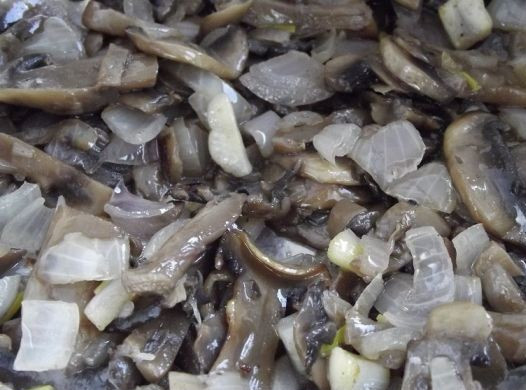 1. Этап. Пирожки с грибами и яйцом: Обжариваем грибы на сковороде с добавлением растительного масла до полуготовности, затем добавляем мелко нарезанный лук и жарим еще 2-3 минуты.