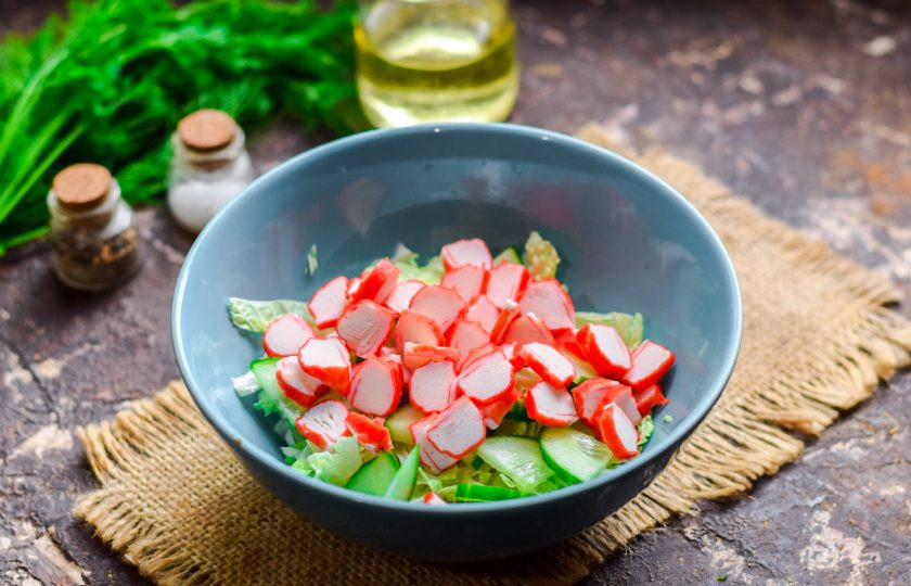 1. Этап. Салат с пекинской капустой, крабовыми палочками и кальмарами: Крабовые палочки нарежьте небольшими кружочками, добавьте в салат.