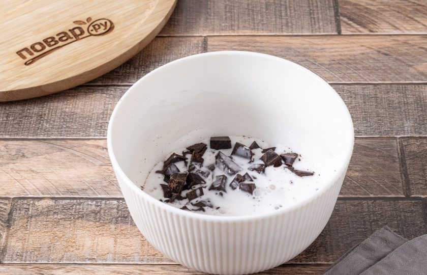 1. Этап. Постный шоколадный кекс: Если хотите покрыть кекс шоколадным кремом, то порубите шоколад на маленькие кубики. Разогрейте кокосовое молоко и влейте его в миску с шоколадом. Размешайте до однородной консистенции. Накройте пленкой и остудите в холодильнике получившуюся смесь 30-60 минут.