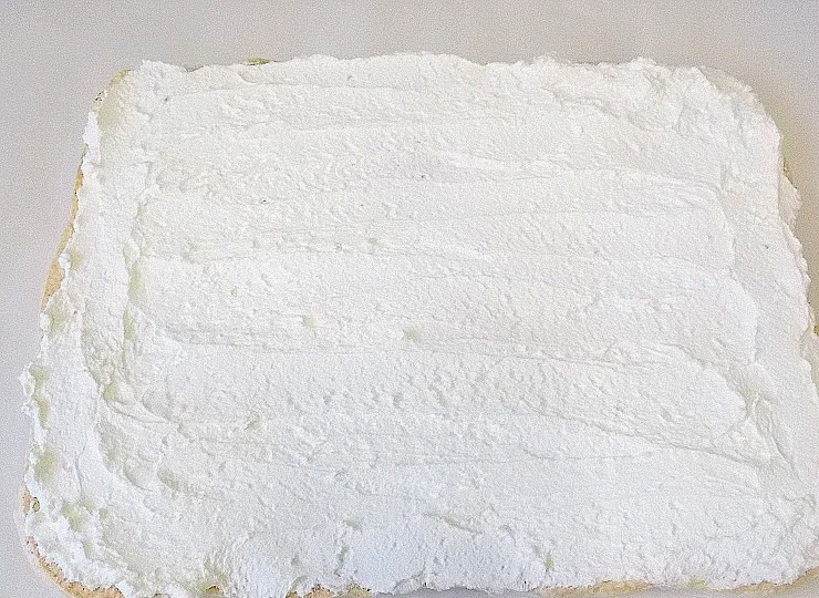 1. Этап. Меренговый рулет с малиной: Промажьте пласт сливочным кремом.