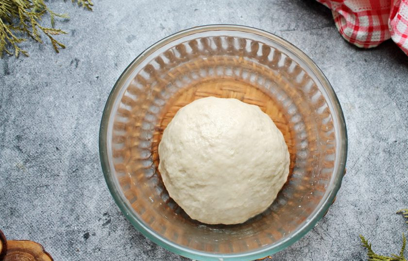 1. Этап. Булочки с голубикой: Частями добавляйте просеянную муку и замесите мягкое, не липкое тесто. Вымешивайте тесто в течение 10 минут, сформируйте шар и выложите в смазанную маслом глубокую миску.