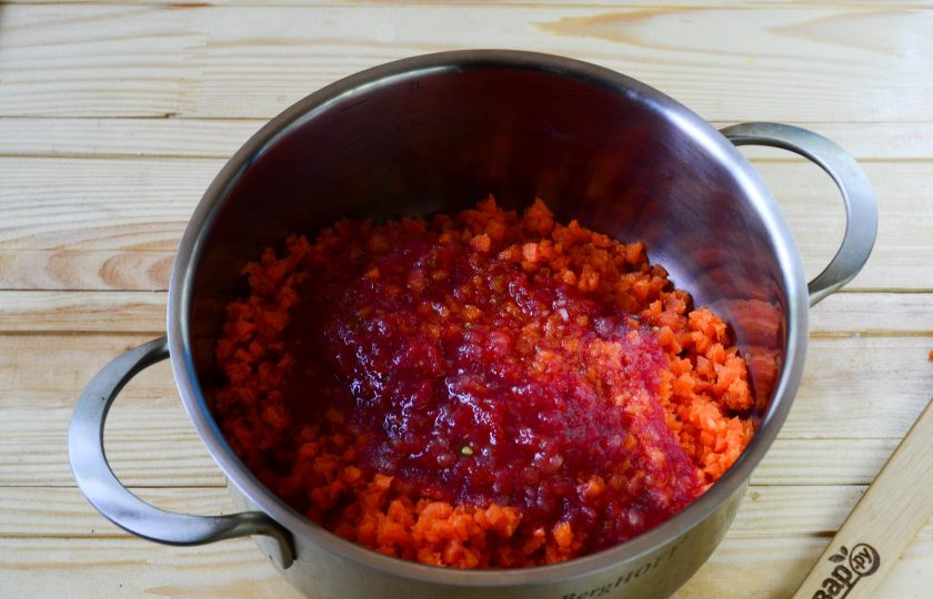 1. Этап. Морковная икра на зиму: Помидоры также пропустите через мясорубку вместе с очищенным чесноком. Соедините в кастрюле измельченные морковь и помидоры с чесноком.