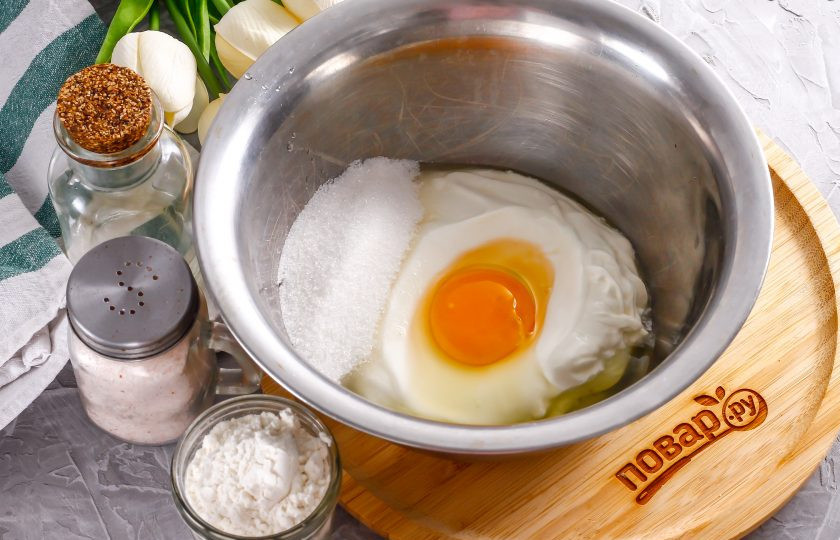 1. Этап. Панкейки на сметане: Выложите сметану в глубокую емкость, вбейте туда же куриное яйцо, всыпьте сахар и соль. Влейте воду и тщательно взбейте венчиком.