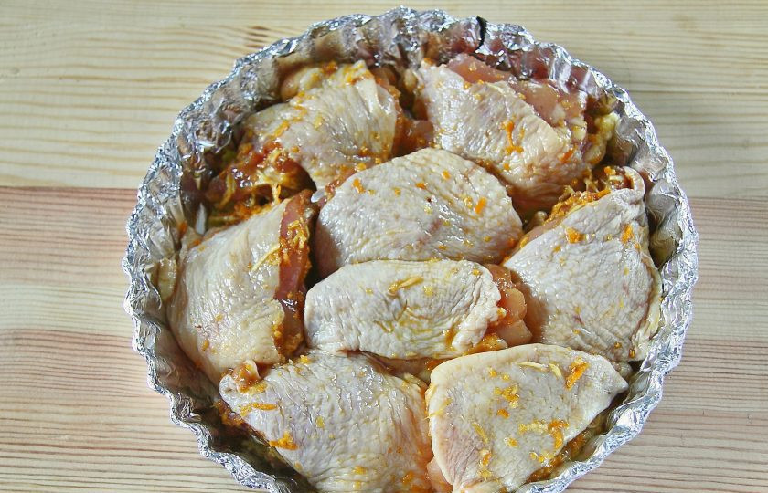 1. Этап. Курица в мандаринах: Форму для запекания застелите фольгой, смажьте маслом и выложите подготовленную маринованную курицу.