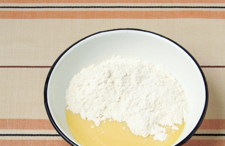 1. Этап. Торт Муравейник классический: Отдельно просейте муку. Затем всыпьте её порциями в основную массу.