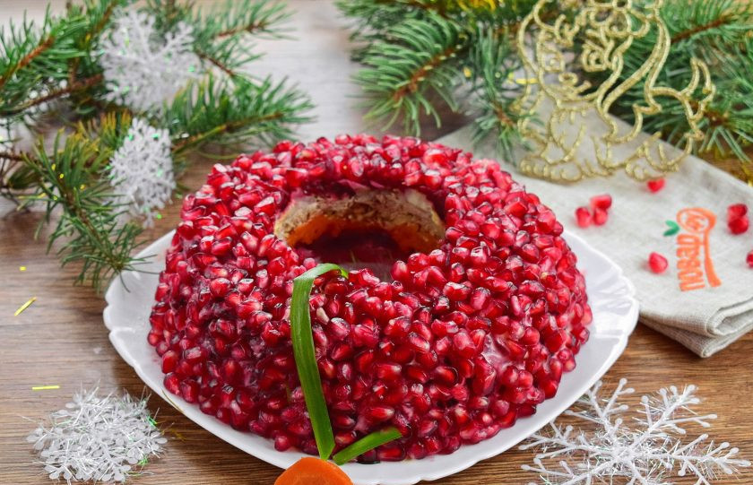 1. Этап. Салат Гранатовый ошейник: Верх салата покройте зернами граната. Аккуратно вытащите стакан. Концы зеленого лука соедините и прижмите кружком моркови. Дайте салату настояться и подавайте к столу. Счастливого Нового года!