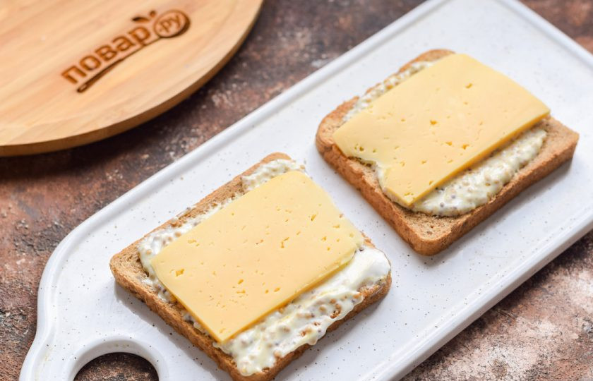 1. Этап. Индийские бутерброды: Твердый сыр нарежьте пластинами, выложите поверх соуса.