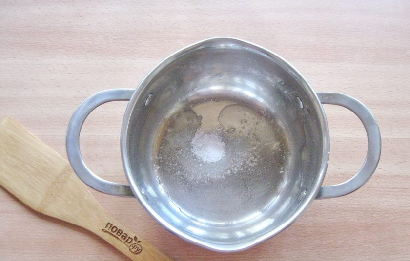 1. Этап. Капустный салат по-немецки: В кастрюлю с толстым дном налейте подсолнечное масло, насыпьте соль и сахар.