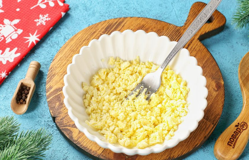 1. Этап. Закуска Дракончики на Новый год 2024: Аккуратно извлеките желтки и разотрите их в крошку.