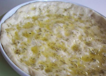 1. Этап. Итальянский хлеб фокачча: 3. Смазать маслом форму для запекания и выложить на него тесто. Размять тесто по всей форме. Хорошо смазать тесто душистым маслом.