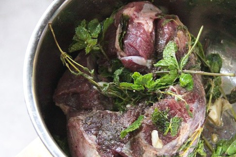 1. Этап. Баранина на углях: Бедренную часть мариновать нет смысла, ведь ее мы будем запекать в фольге вместе с травками, там все и пропитается по ходу дела. А вот корейку следует заранее разрезать по ребрам, также натереть солью и перцем, нашпиговать чесноком, сбрызнуть оливковым маслом и оставить полежать в смеси травок на 2-3 часа.