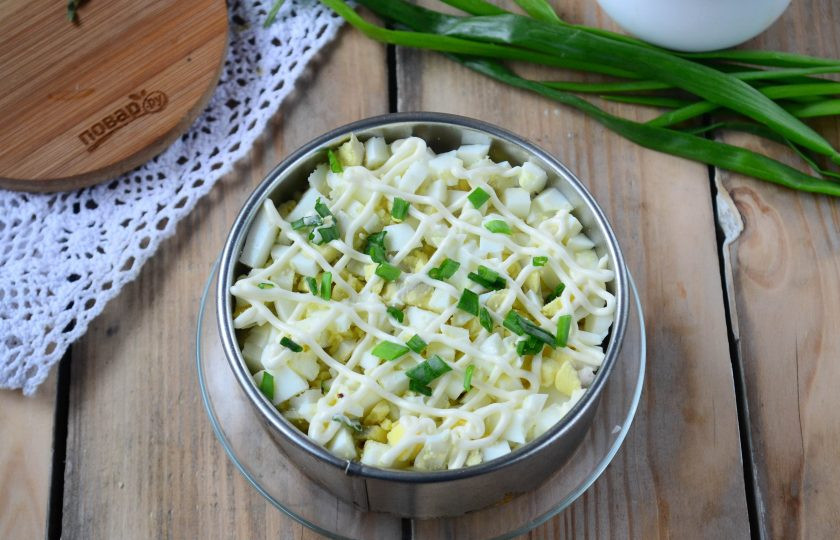 1. Этап. Салат слоеный Рандеву: Следующий слой — мелко порезанные яйца, затем майонез и немного мелко нарезанного зеленого лука.