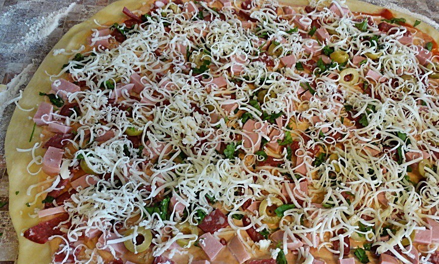 1. Stage. Mini pizzas: Chop the sausage and bratwurst into smaller pieces and spread evenly over the rolled out dough. Slice the olives and spread them out the same way. Chop parsley greens (you can also chop basil, if you have it) and sprinkle on top. Cover the whole thing with grated mozzarella.