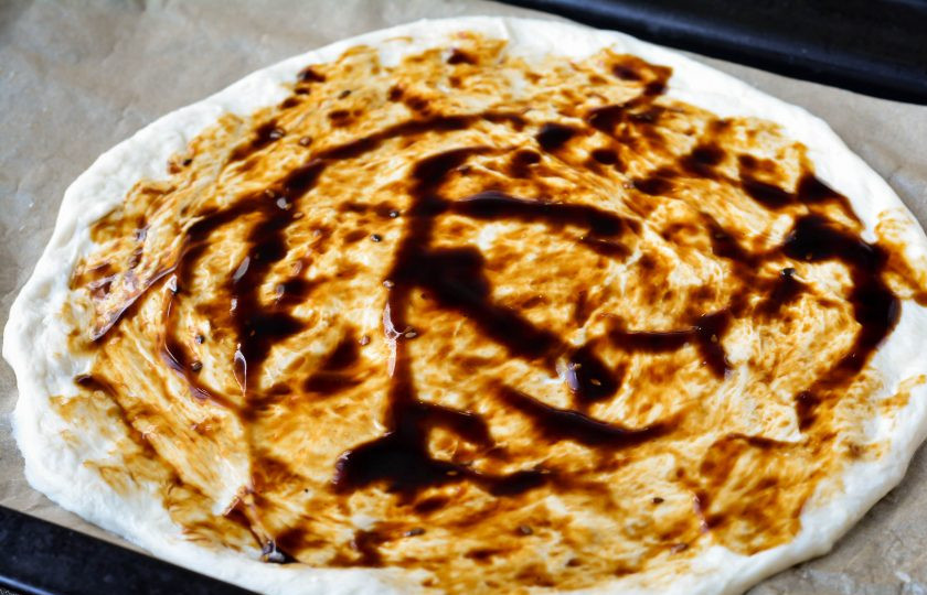 1. Этап. Пицца Терияки: Тесто раскатайте и смажьте густым соусом терияки.