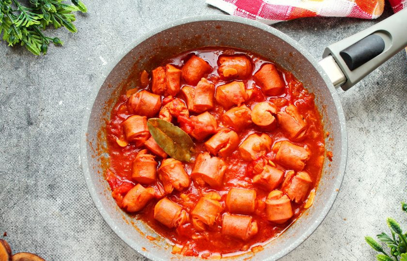 1. Этап. Сосиски в томатном соусе с рисом: Доведите все до кипения, закройте крышкой и тушите на медленном огне в течение 20 минут, перемешивая 2-3 раза.