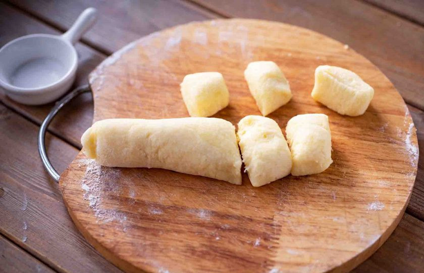 1. Этап. Ньокки с креветками: Рабочую поверхность припылите небольшим количеством муки. Из картофельного теста сформируйте небольшие колбаски, нарежьте их ножом на части.