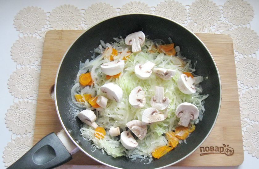 1. Этап. Капуста тушеная с курицей и грибами: Накройте сковороду крышкой и тушите овощи 10-15 минут, периодически перемешивая. Затем добавьте нарезанные шампиньоны.