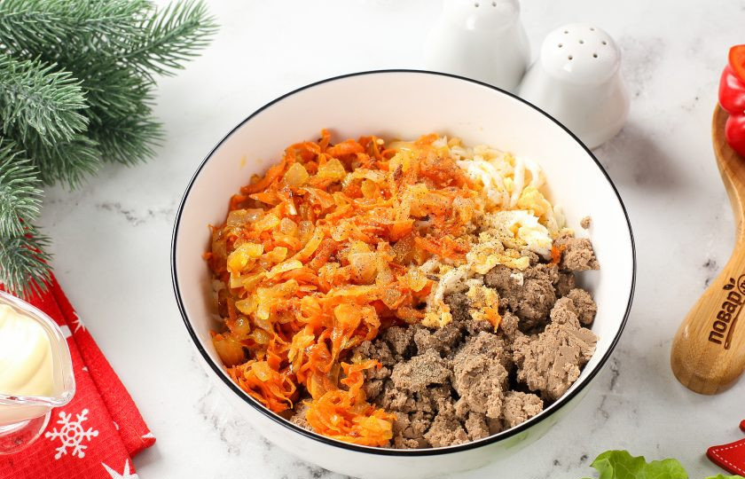 1. Этап. Рулет Новогодняя змея: Измельчите печень в блендере или при помощи мясорубки, добавьте натёртые на крупной тёрке яйца и обжаренные овощи. Посолите и поперчите начинку по вкусу. Заправьте майонезом и перемешайте.