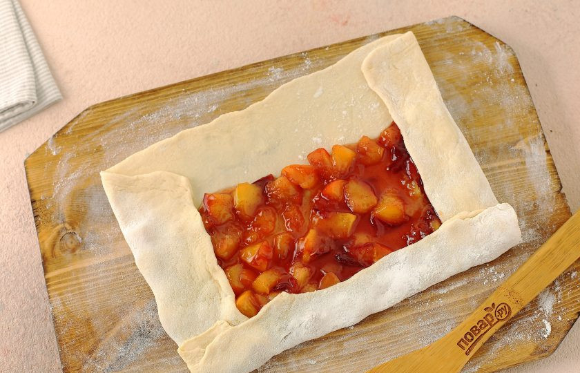 1. Этап. Штрудель с персиками: Тесто тонко раскатайте в форме прямоугольника. Ближе к одному краю выложите начинку. Подверните края, и сверните тесто в рулет. Место шва должно оказаться сверху, тщательно защипните его.