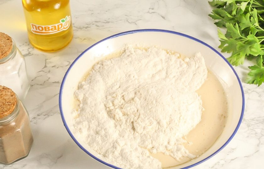 1. Этап. Вареники с сюрпризами на Старый Новый год: Всыпьте по частям пшеничную муку высшего сорта и замесите мягкое, плотное тесто.
