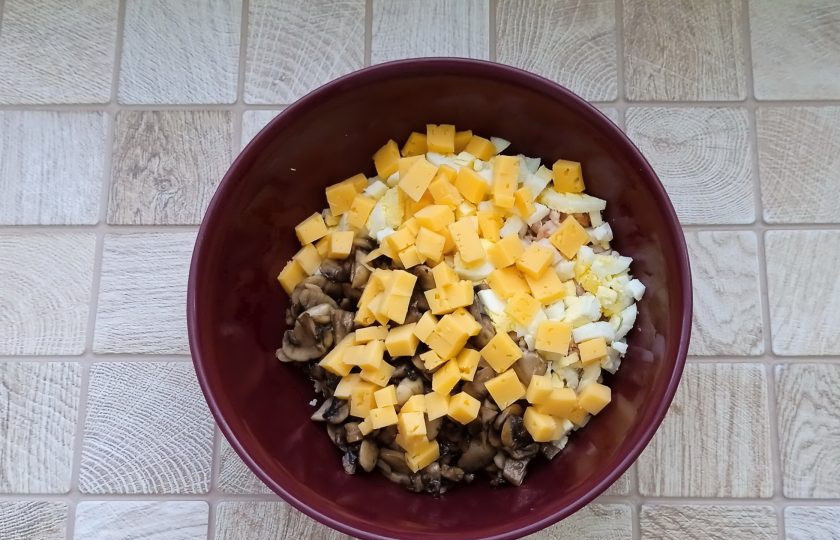 1. Этап. Салат Любимый с курицей и грибами: Добавьте в миску нарезанный небольшими кубиками твёрдый сыр.