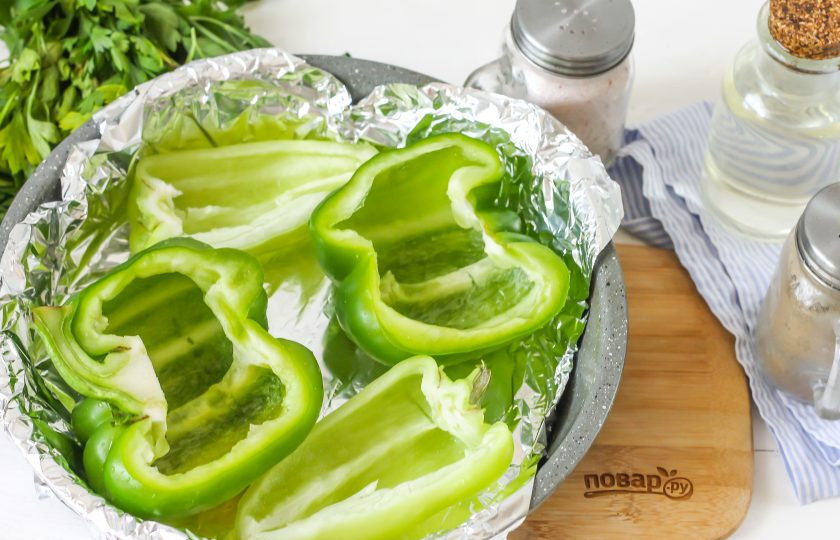 1. Этап. Запеченные перцы с фетой: Болгарские перцы разрежьте вертикально на две половинки и удалите семена. Промойте каждую из них в воде и обсушите бумажным полотенцем. Форму смажьте растительным маслом и выложите в нее овощи.