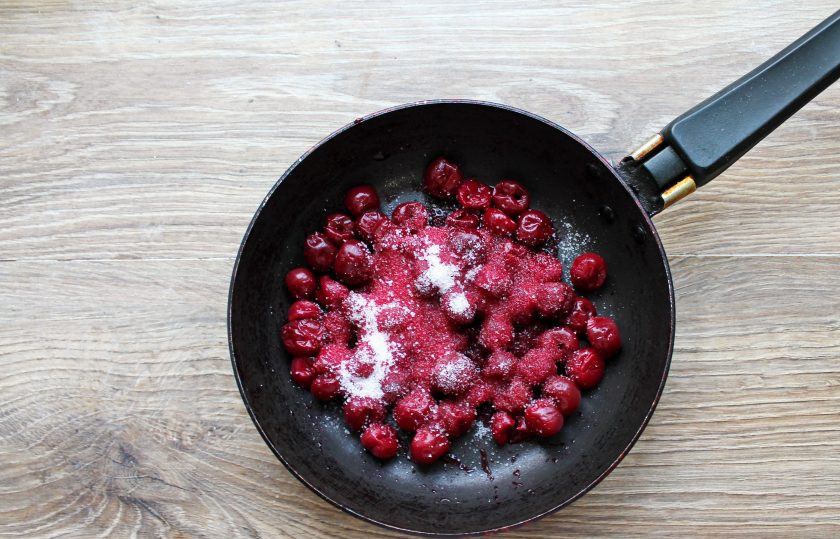 1. Этап. Шоколадные блины с вишней: С вишни слейте сок в миску. Ягоды без косточек выложите в сковороду, добавьте сахар и поставьте на средний огонь. Проварите вишню в течение 5-7 минут.