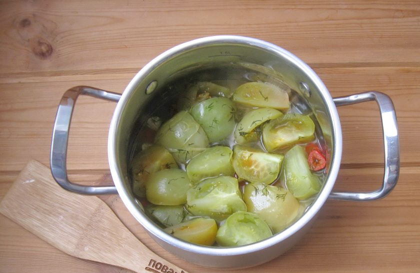 1. Этап. Зеленые помидоры дольками на зиму: После достаньте кастрюлю из холодильника, поставьте на плиту и тушите помидоры на минимальном огне 10-12 минут. В конце налейте уксус и перемешайте.