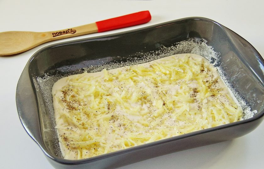 1. Этап. Студенческий пирог: Картофель натрите на крупной терке и выложите на тесто. Посолите картофель и поперчите по вкусу.