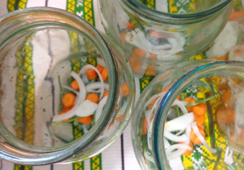 1. Этап. Быстрая закатка огурцов: 1. Огурцы моем и заливаем холодной водой. Пусть стоят три часа. Тем временем стерилизуем банки, выкладываем в них кусочки морковки и лука, а также лавровый лист, перец и укроп (по вкусу).