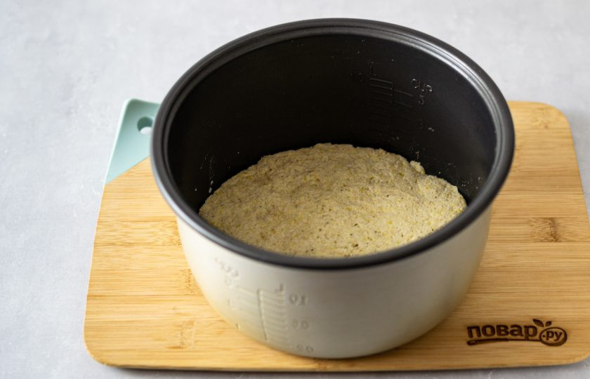 1. Этап. Безглютеновый хлеб в мультиварке: Выложите тесто в чашу для мультиварки, влажными руками разровняйте хлеб.