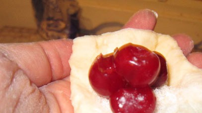 1. Этап. Сладкие пирожки с вишней: 3. В серединку выкладываем вишни и закрываем. Вишни лучше поколоть. У меня есть на такой случай замороженные ягоды, поэтому я делаю выпечку круглый год. Летом особенно вкусные пирожки со свежими ягодами.