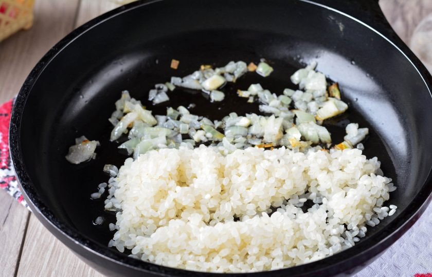 1. Этап. Рис с рыбными консервами: Обжарьте лук на растительном масле до слегка золотистого цвета, добавьте в сковороду промытый рис.