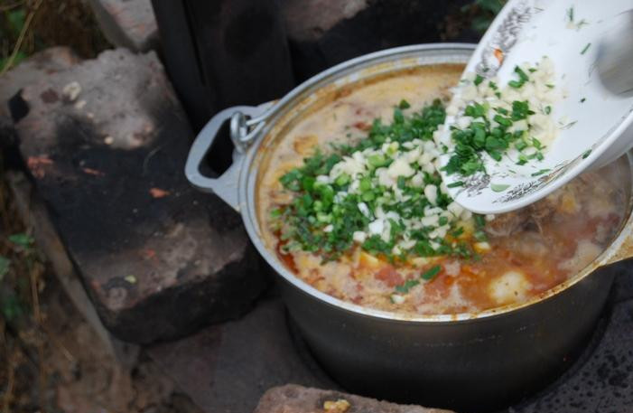 1. Этап. Шулюм из баранины на природе: 6. Теперь снимаем шулюм с огня, добавим пиво, зелень и измельченный чеснок. Даем блюду настояться, по возможности, под крышкой.