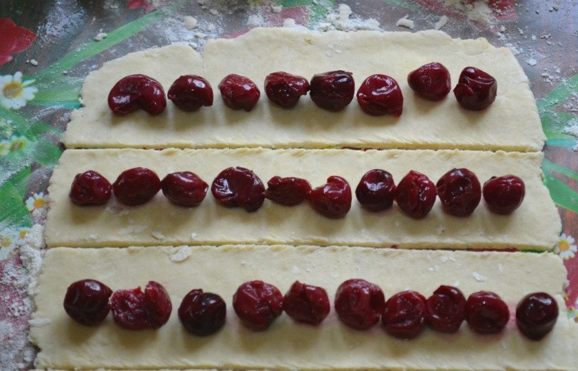 1. Этап. Торт Сердце: Каждую часть раскатайте очень тонко и разрежьте на 5 частей. Выложите вишню дорожкой на каждую полосочку.