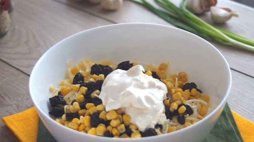1. Этап. Салат Кукуруза: В миске смешайте чернослив с сырами и 1/3 банки кукурузы. Заправьте ингредиенты майонезом. Добавьте измельчённый чеснок. Перемешайте.