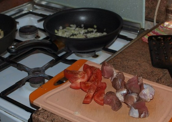 1. Этап. Телятина, жареная на сковороде: Пока обжаривается репчатый лук, мы нарезаем помидор дольками, а мясо режем на кусочки.