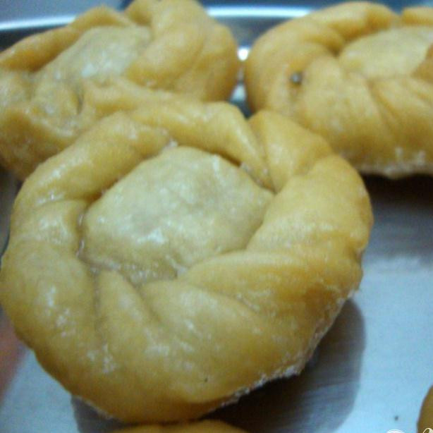 1. Этап. Пончики Бадуша: Переложите готовые пончики в сахарный сироп и дайте им полежать там пару минут затем выньте из кастрюли и переложите на железный поднос. Если сироп сильно загустеет подогрейте на плите.