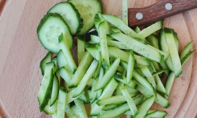 1. Этап. Салат из кальмара с огурцом: Огурцы вымойте и обсушите. Отрежьте у них кончики с обеих сторон. Затем нарежьте овощ соломкой. По желанию вы можете очистить предварительно огурцы от кожицы.