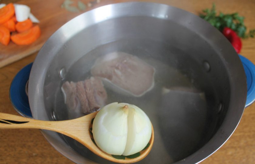 1. Этап. Бульон из говяжьего языка: В кипящий бульон добавляем разрезанный на 2 части лук.