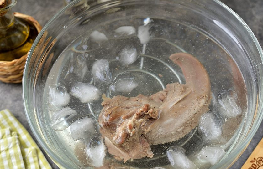 1. Этап. Язык отварной с хреном: Налейте в глубокую миску холодную воду, добавьте немного льда, выложите в нее отваренный язык. Подержите язык в ледяной воде несколько минут, затем снимите кожу и вытрите его насухо бумажными полотенцами.