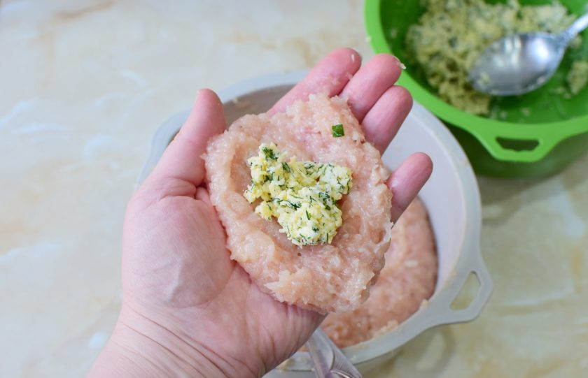 1. Этап. Куриные котлеты с начинкой из сыра и зелени: Для котлеты возьмите немного фарша и в центр выложите сырную начинку. Слепите котлету, чтобы начинка осталась внутри. Обваляйте котлету в панировочных сухарях.