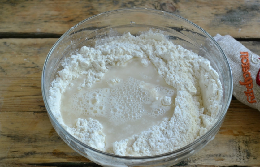 1. Этап. Ватрушка с творогом: В сухой смеси сделайте воронку, влейте туда воду. Хорошенько перемешайте и добавьте растительное масло.