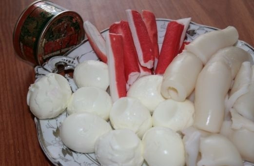 1. Этап. Салат с кальмарами и красной икрой: 1. Вот такой набор ингредиентов вам потребуется. Кальмары очистите от пленок и отварите в подсоленной воде 3-4 минуты после закипания. Сварите вкрутую яйца.